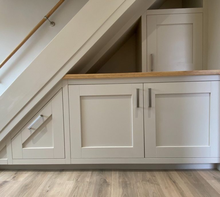 A black and white spaniel standing on a workbench in a workshop.
