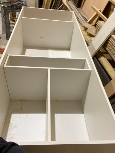 White storage unit with multiple compartments for organising items.